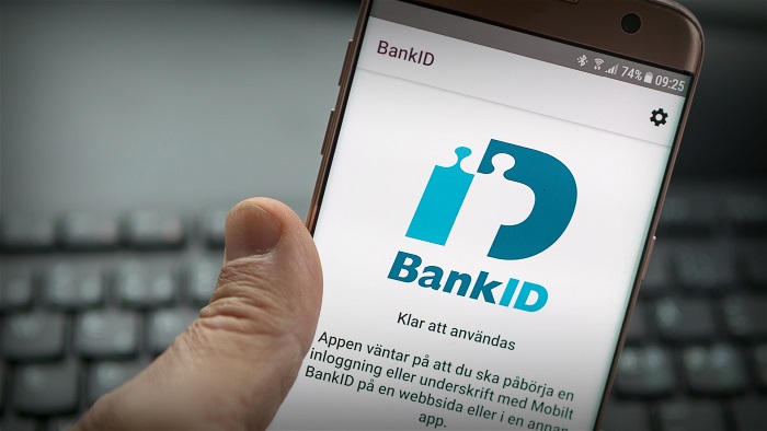 En hand som håller i en mobil med BankID