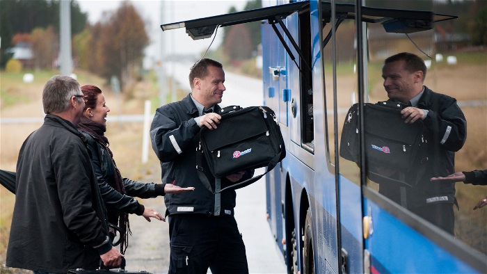 busschaufför lastar in bagage i en buss 