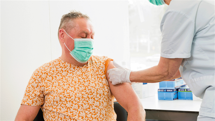 En man får ett plåster efter att ha vaccinerats mot covid-19.