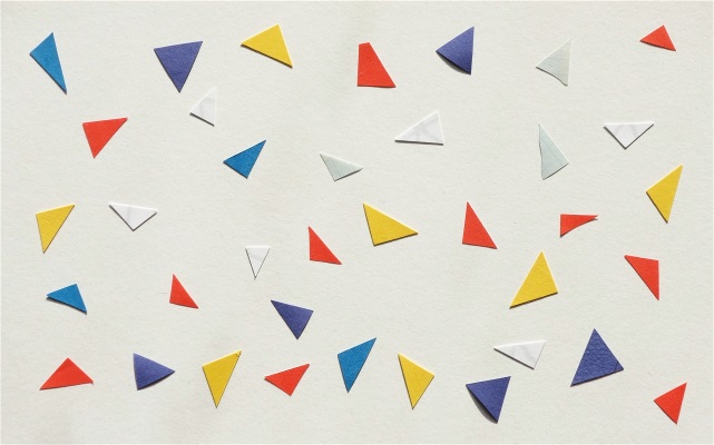 Fotografi med färgade trekanter i papper på en vit yta