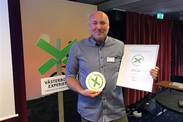 Patrick Edin, Forsknäckarna, håller glatt upp ett diplom för Västerbotten Experience.