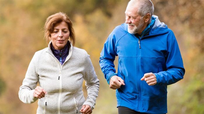 En äldre kvinna och en äldre man som joggar tillsammans.