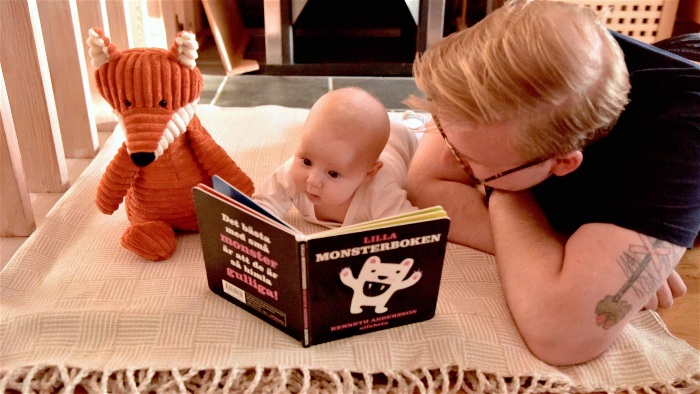 Foto som visar en bebis som läser med sin pappa